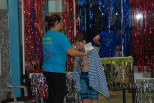 Coach-shannon-giving-her-kiddos-awards-at-a-swim-meet
